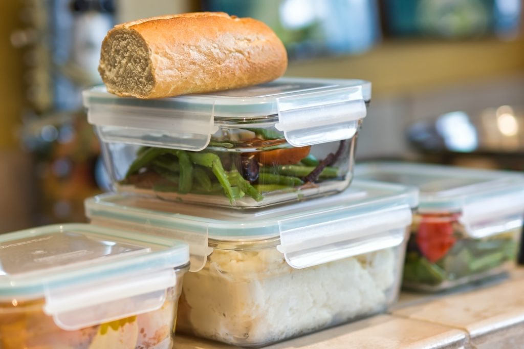 Close-up of containers of leftovers stacked on kitchen counter - meal