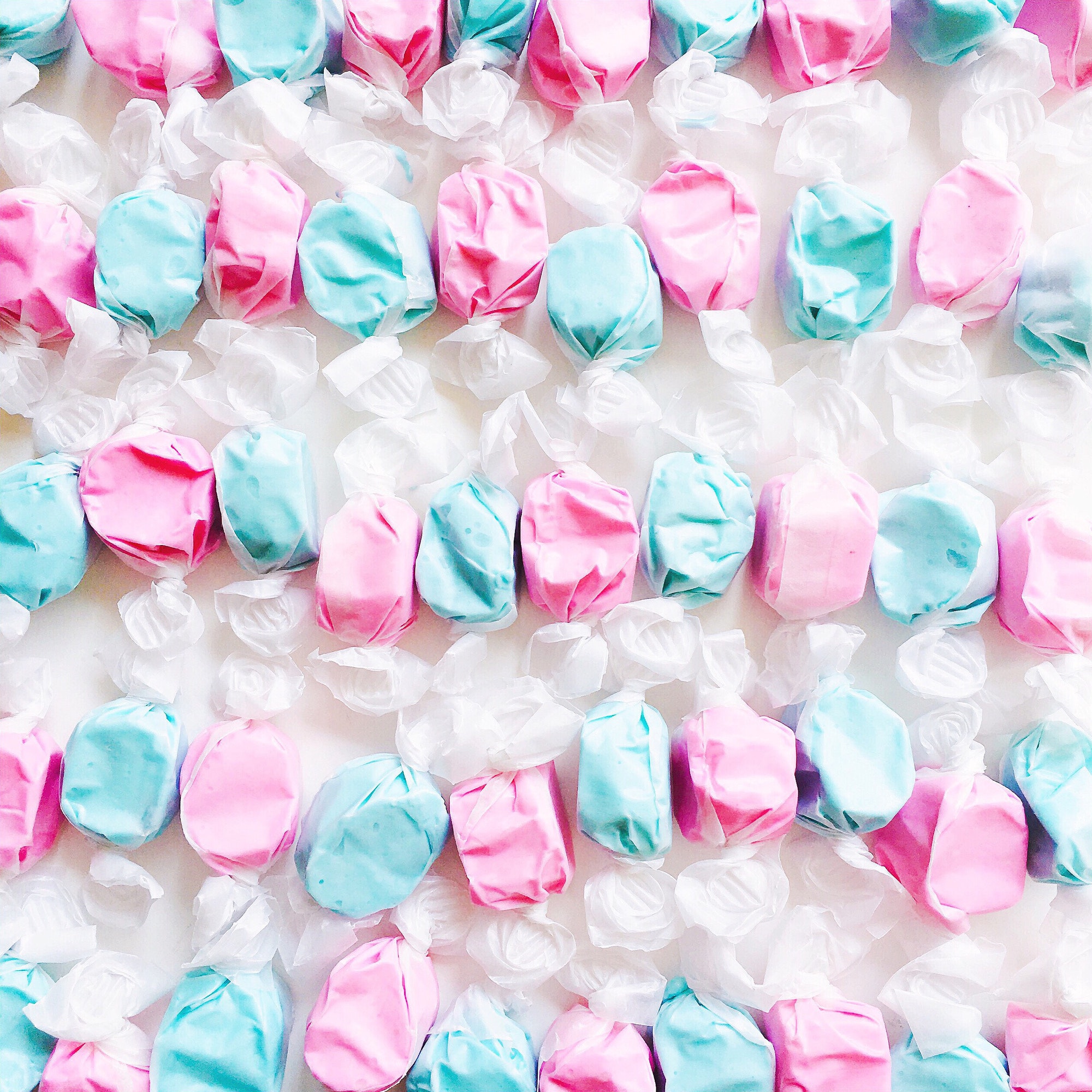 Neatly lined rows of wrapped alternating pattern pink and blue taffy ...