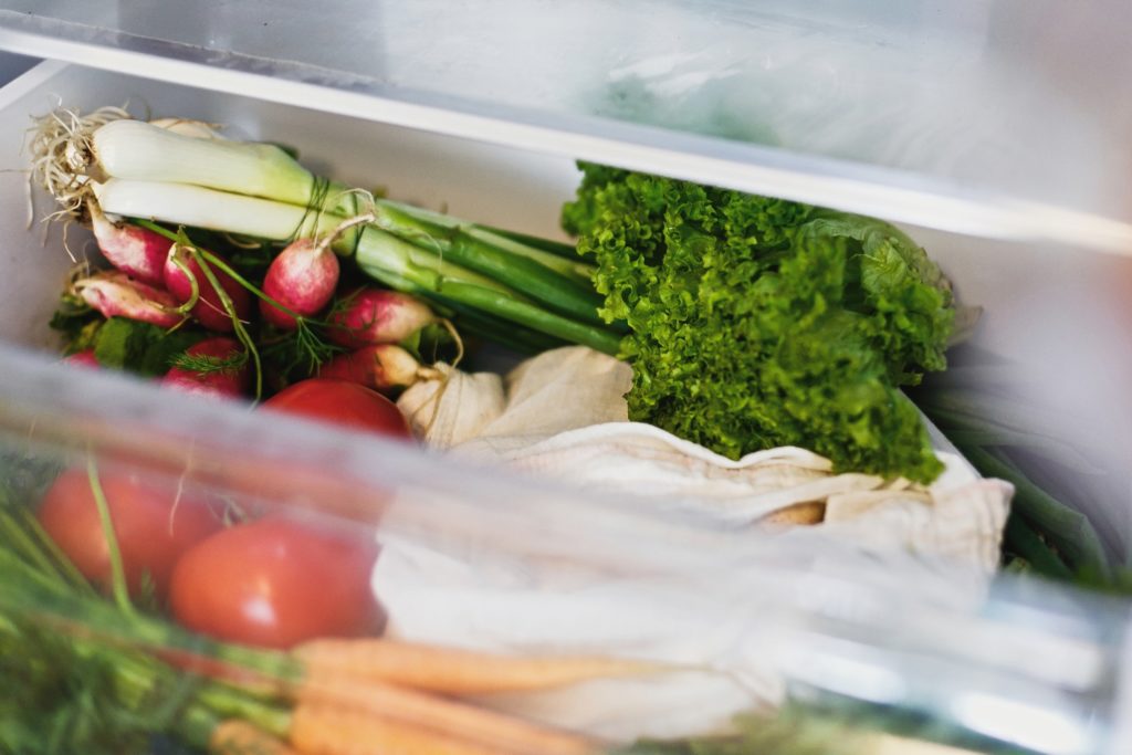 Fresh vegetables in opened drawer in refrigerator