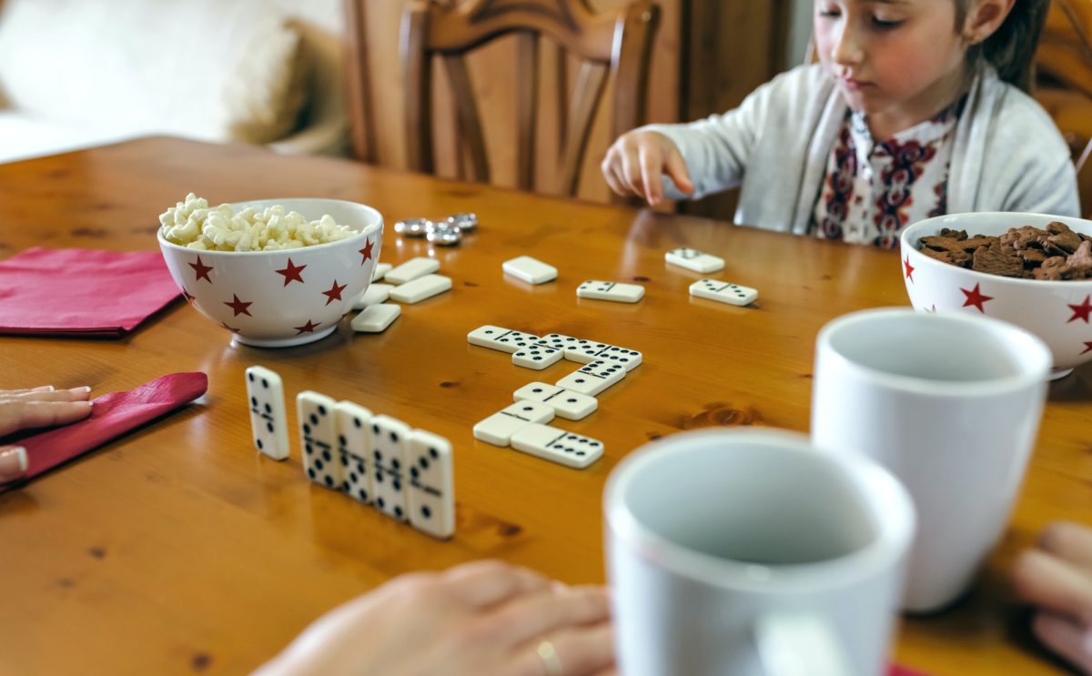 Girl playing domino with her family