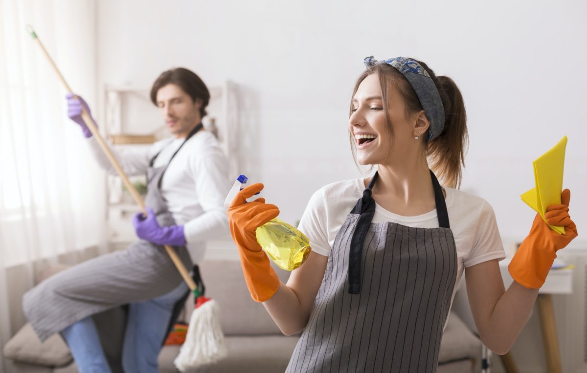 Playful Couple Having Fun While Cleaning Flat Together